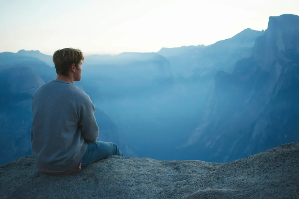 A person looking out across a mountain valley