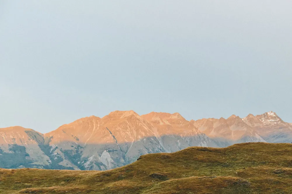 Sunlit mountains around a peaceful retreat landscape